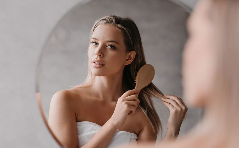 hair-treatment-selfcare-woman-brushing-hair-mirror-kutting-korner-wolviston.jpg