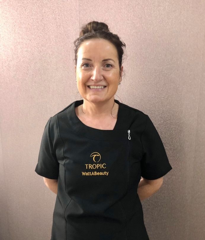 Margaret Watt, owner of The Zen Den @ Watt A Beauty in Glasgow, smiling in a black Tropic uniform inside the salon.